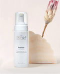 Renew foaming cleanser next to a marble block and pink flower.